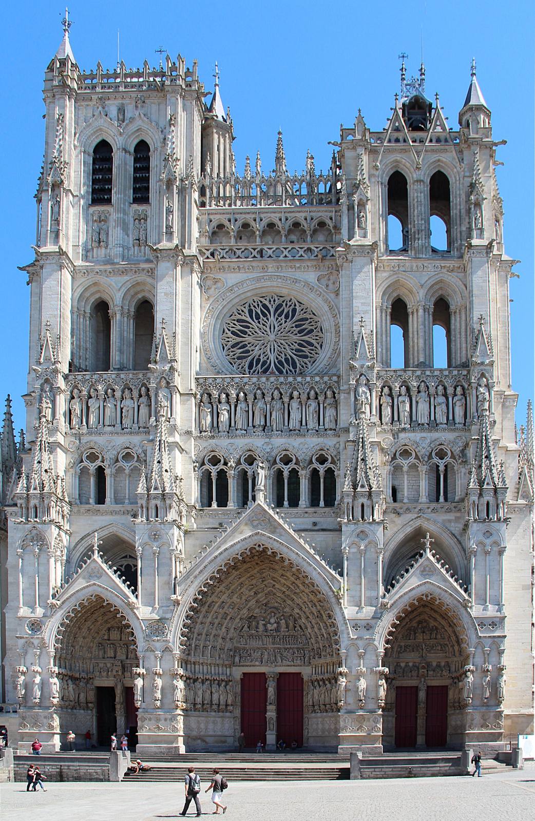 The west front of Amiens Cathedral, with deep sculpted portals and two towers of unequal height.