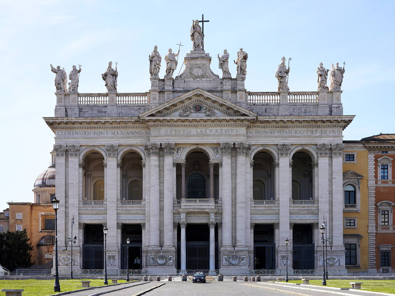 The white classical façade of St John Lateran, topped by a row of colossal statues.