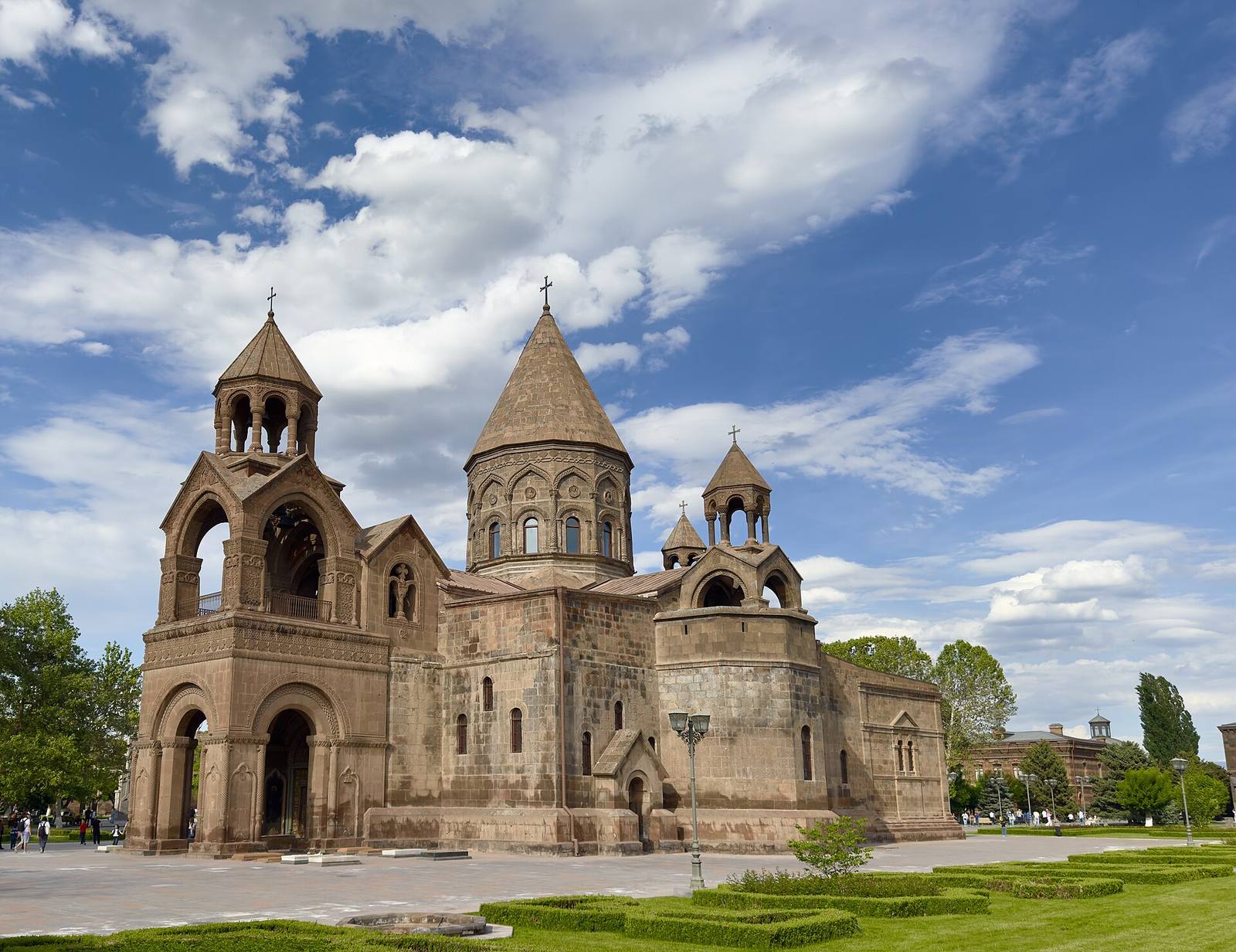 Etchmiadzin Cathedral’s stone domes and belfry under a cloudy sky.