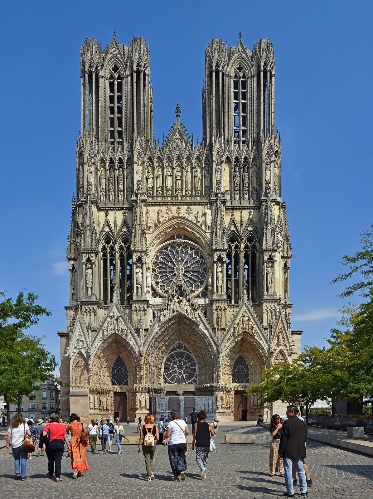 The richly sculpted west front of Reims Cathedral with its two towers.