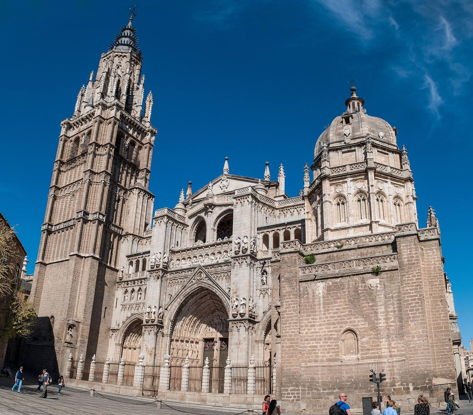 Toledo Cathedral’s Gothic tower and façade under a blue sky.