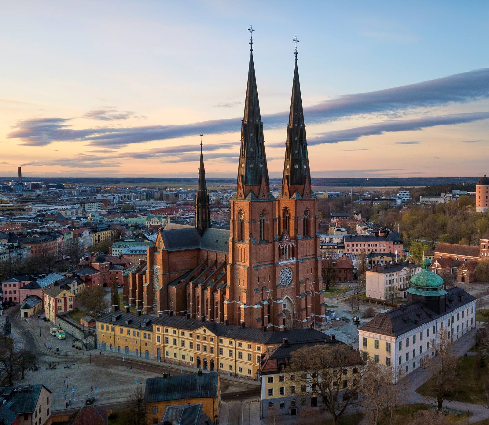 Aerial view of Uppsala Cathedral’s red-brick nave and twin spires.